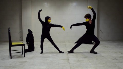 Dancers in black with yellow details performing Zard